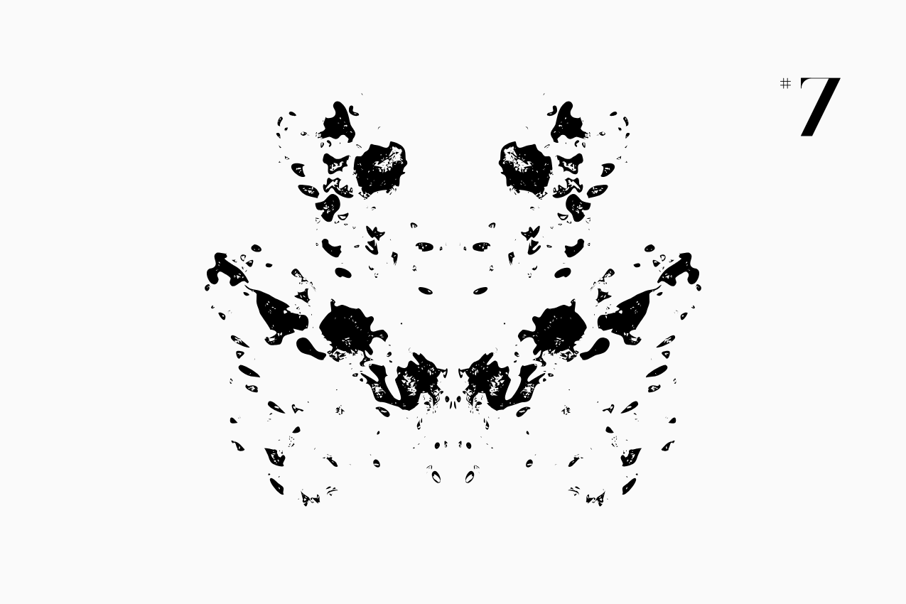 A bilateral, Rorschach-style inkblot specimen for the “In Other Words” series from The Subtext Review. The charcoal-black symmetrical splatter is centered on a cream paper background, labeled as Puzzle No. 7 in a classic serif typeface.