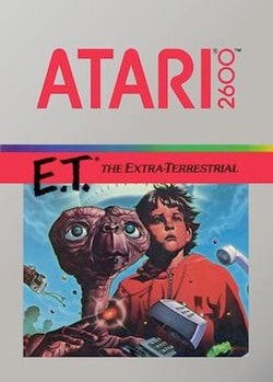 Artwork of a grey, vertical rectangular box. The top half reads "Atari 2600. E.T.* The Extra-Terrestrial". The bottom half displays a drawn image of a brown alien with a large head and long neck beside a young boy in a red, hooded jacket. Artwork of a grey, vertical rectangular box. The top half reads "Atari 2600. E.T.* The Extra-Terrestrial". The bottom half displays a drawn image of a brown alien with a large head and long neck beside a young boy in a red, hooded jacket.
