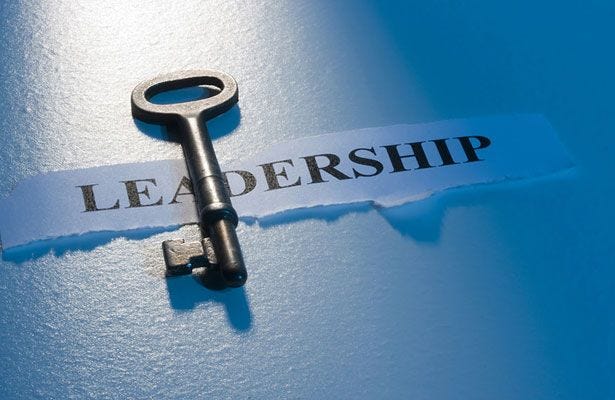 This may contain: a key that is attached to a piece of paper with the word leadership written on it