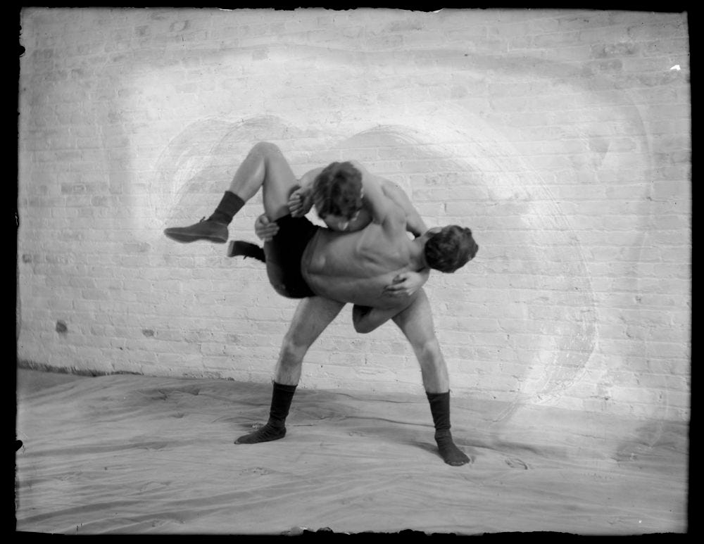 Photo of two wrestlers, one of whom has picked up the other.