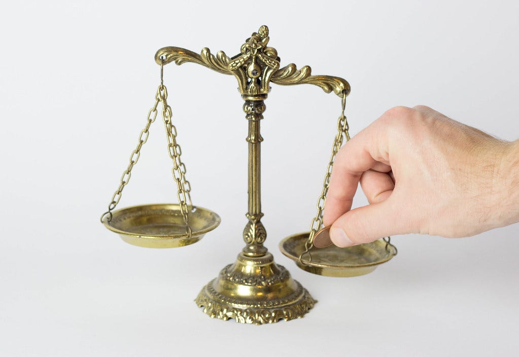 Hand Stacked Coins With Justice Scale