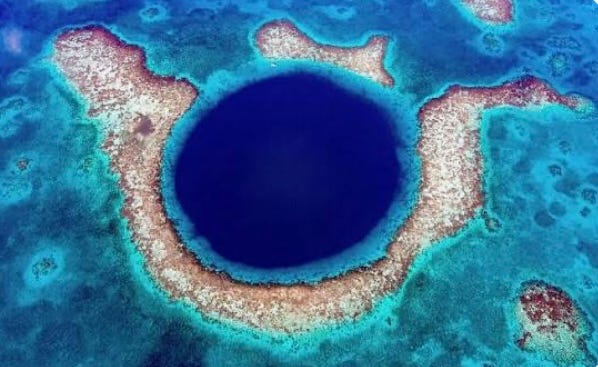 A blue hole in the ocean with Great Blue Hole in the background

AI-generated content may be incorrect.