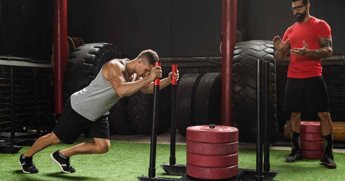 Man performing the sled push exercise in the gym
