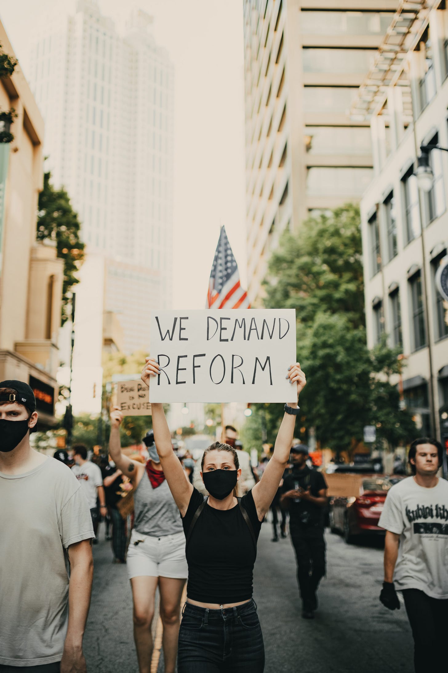 A protester holds a sign saying "We demand reform" at a rally.