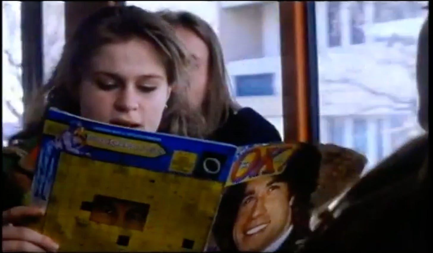 A young, white woman on a bus reading a magazine with a young, 1970s John Travolta on the cover A young, white woman on a bus reading a magazine with a young, 1970s John Travolta on the cover