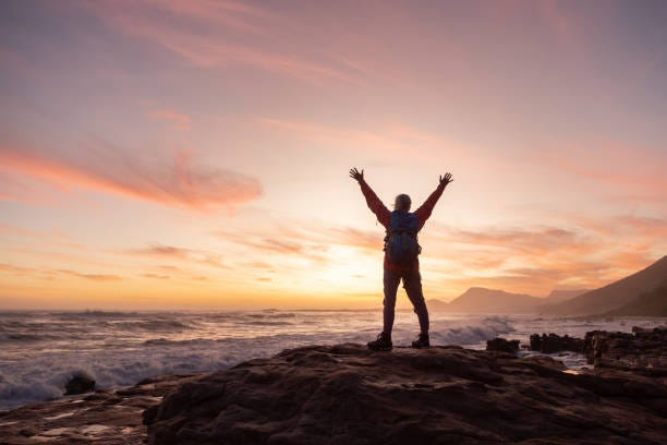 senior woman celebrating reaching the sea on a hike - achievement stock pictures, royalty-free photos & images