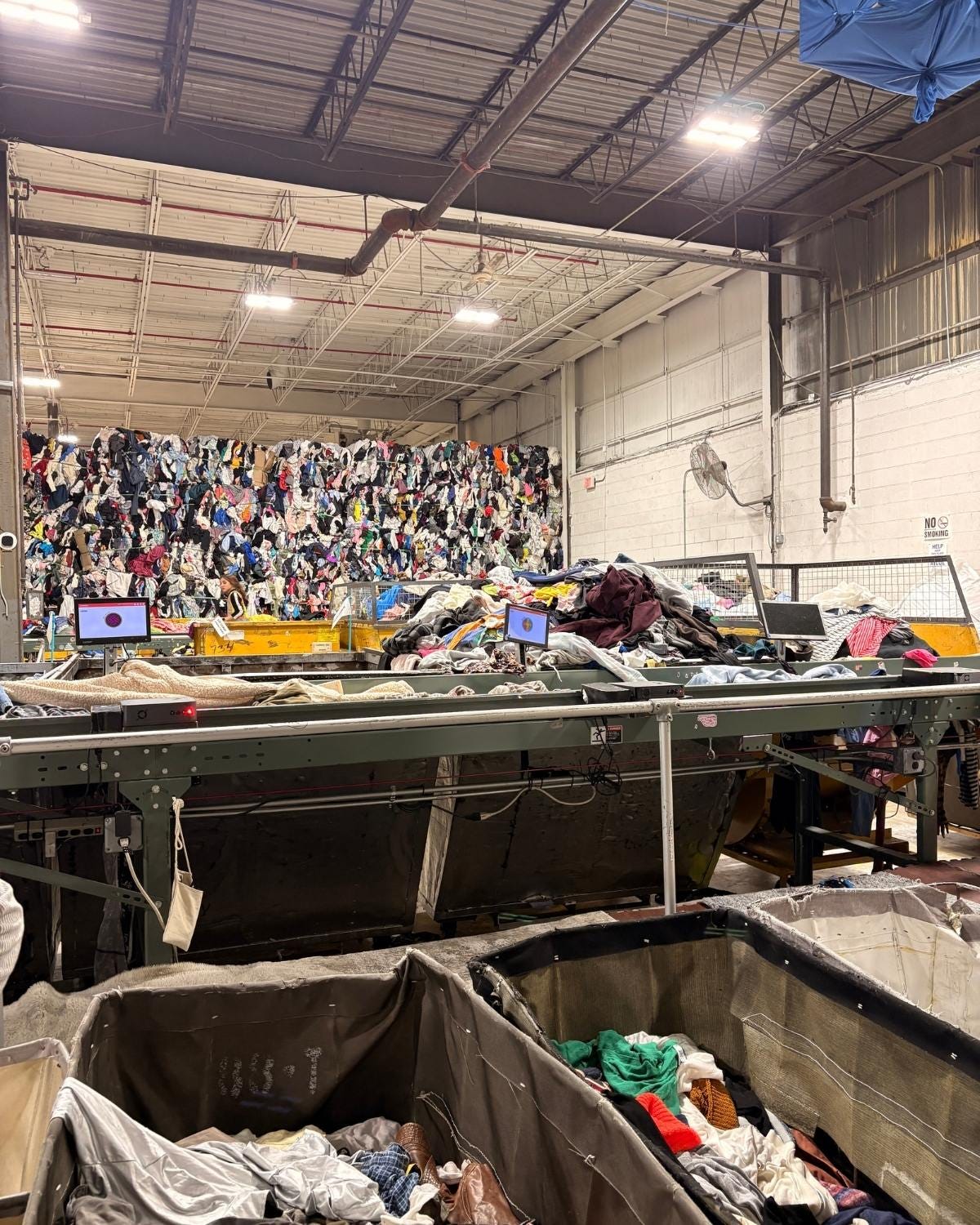 Stream of clothing getting sorted on conveyer belt.
