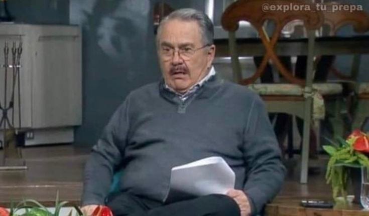 This may contain: an older man sitting on a chair holding a piece of paper