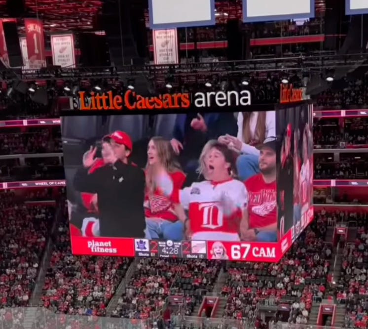 A Red Wings fan doing the "6-7" gesture on the "6-7" Jumbotron