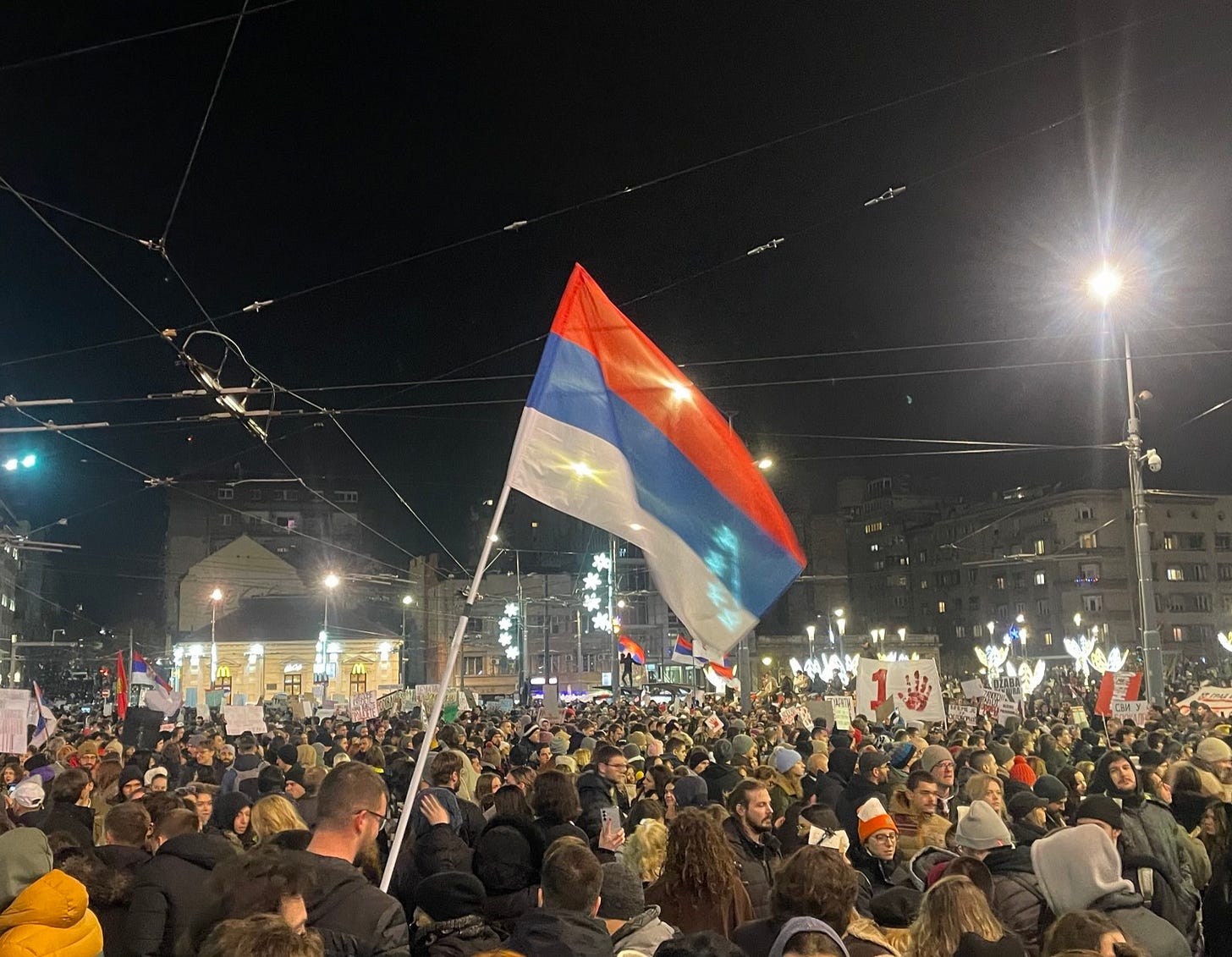 Protesta in piazza Slavija a Belgrado, 22 dicembre 2024, con la bandiera serba Protesta in piazza Slavija a Belgrado, 22 dicembre 2024, con la bandiera serba