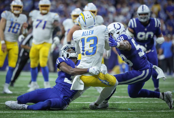 Keenan Allen of the Los Angeles Chargers is tackled by Grant Stuard Bobby Okereke of the Indianapolis Colts during the game at Lucas Oil Stadium on...