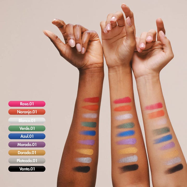 The colorful eyeshadow palette in its golden metal case with a mirror. Shadow swatches on three different skin tones.