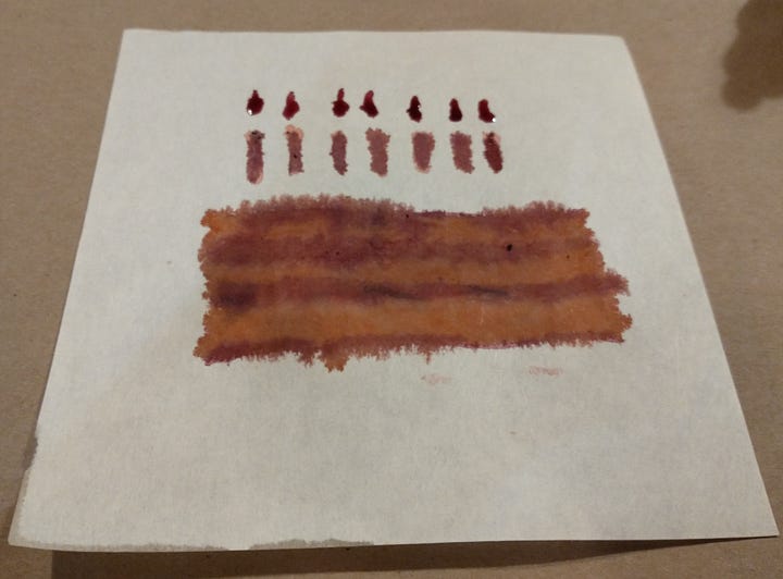 Photo of two ink paintings of a pinky purply birthday cake, one is wet, one is dry