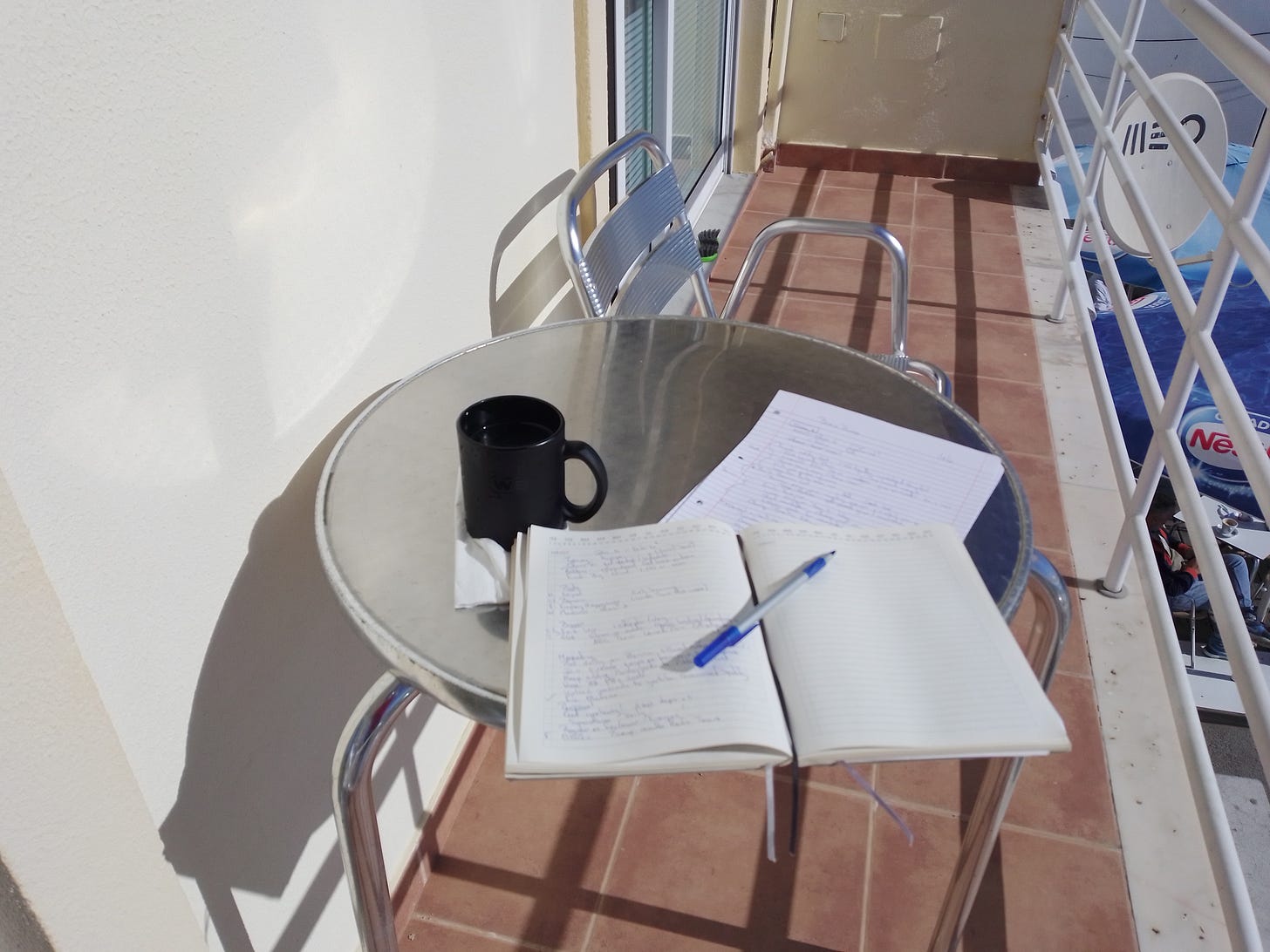 Hey, it's my balcony! It's narrow but there's room for a round metal table and two almost comfy metal chairs. On the table is my planner with Bic stick pen (my favorite) and a cup of coffee which is life itself for me. 