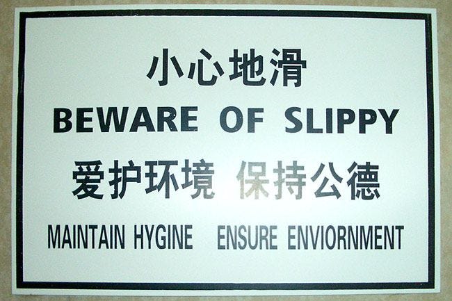 This may contain: a sign that says beware of slippy in english and chinese characters on it