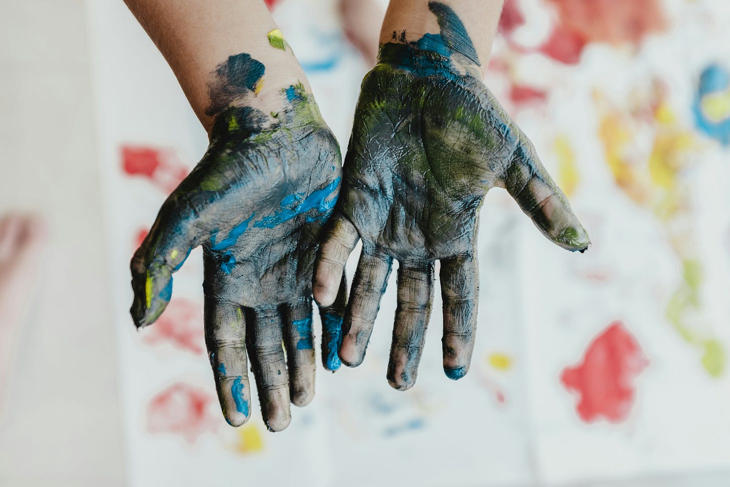 two small hands covered in paint