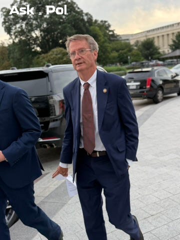 A male politician in a suit with glasses on walks to an awaiting car outside the US Capitol A male politician in a suit with glasses on walks to an awaiting car outside the US Capitol