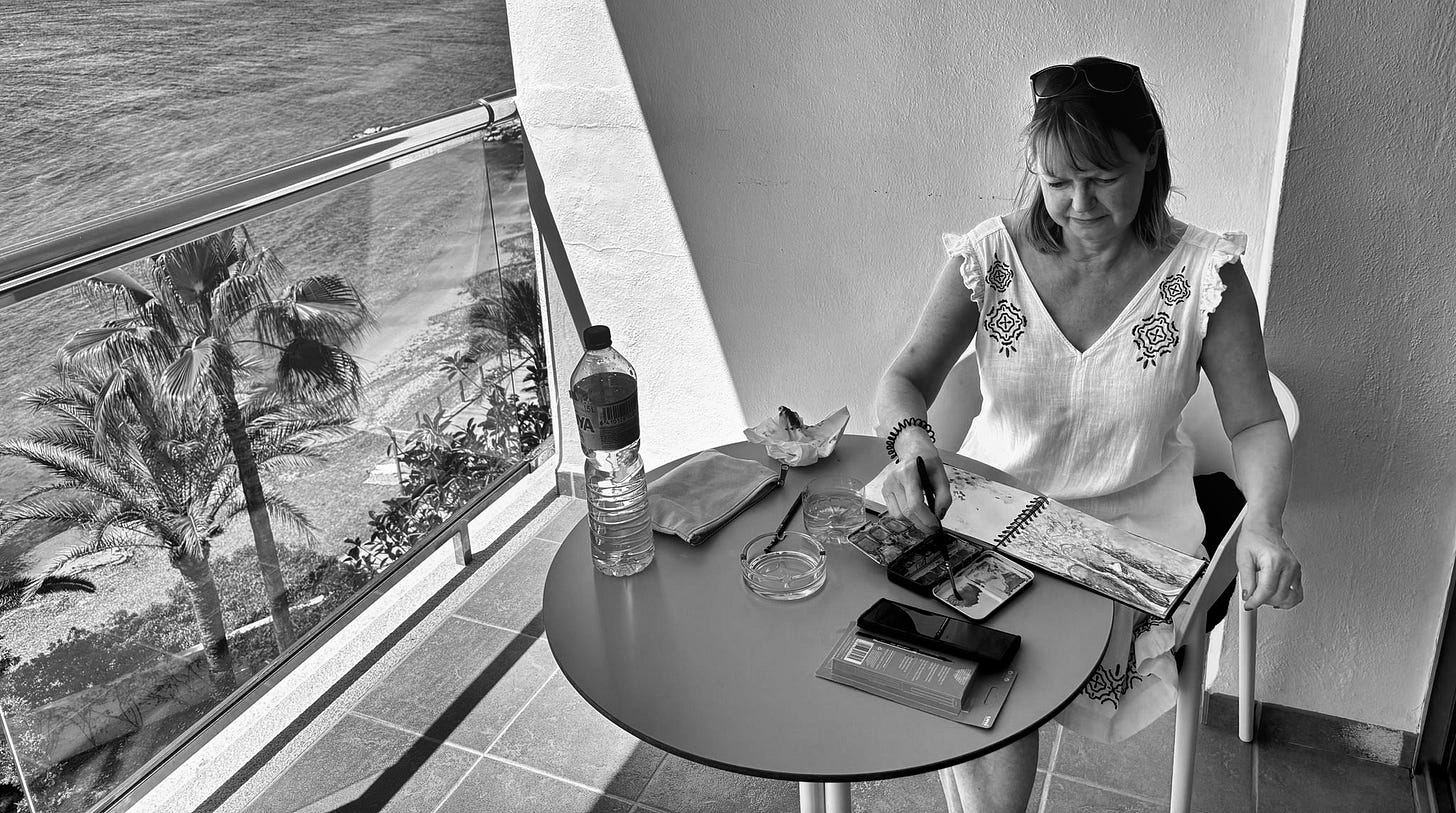 Susan Mills sat painting en plein air