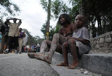 Haiti Earthquake Injured people sit along a road the day after the earthquake struck Port-au-Prince, Haiti, (AP Photo/Jorge Cruz)