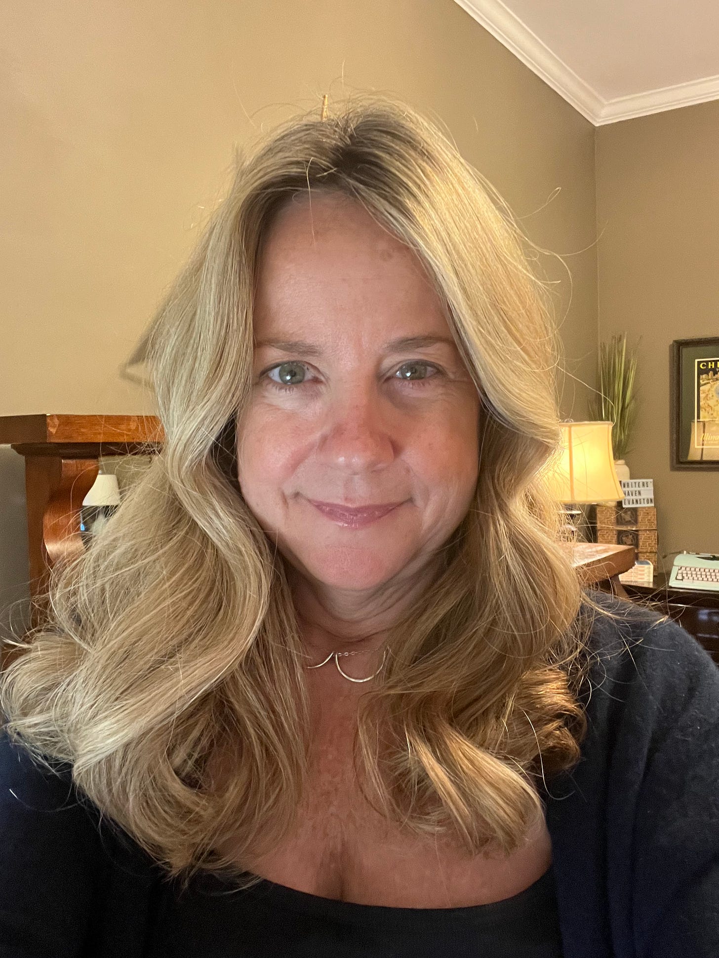 Blonde woman with curled, shoulder-length hair and dark top looking directly at camera Blonde woman with curled, shoulder-length hair and dark top looking directly at camera