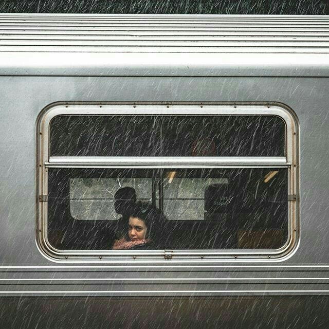 This may contain: a woman sitting in the passenger seat of a train with her head out the window