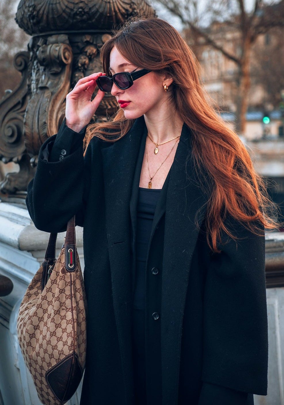 a woman in a black coat and sunglasses a woman in a black coat and sunglasses