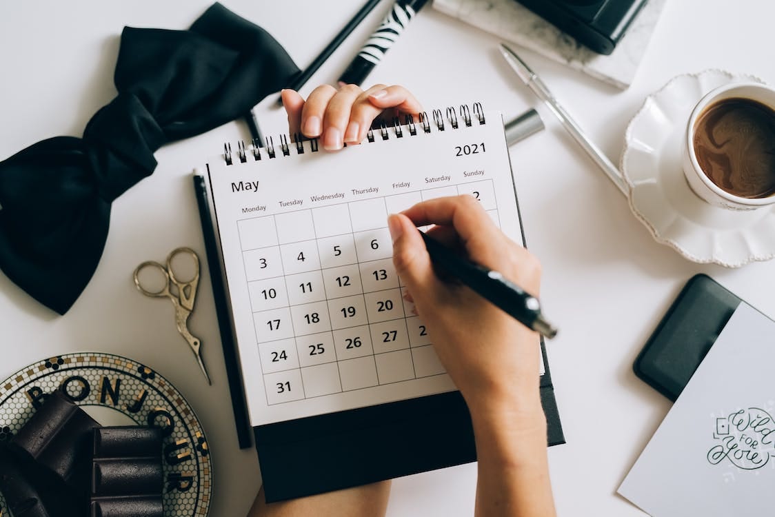 Free A Person Writing on a Desk  Calendar Stock Photo