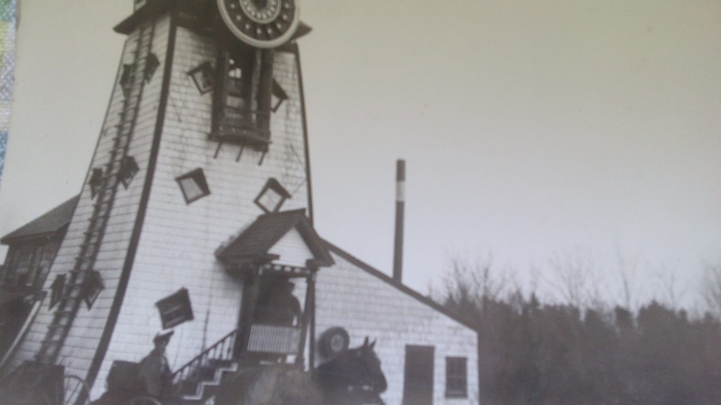 Black and white photo from the 19th century of a horse and wagon in front of a windmill missing it's blades.
