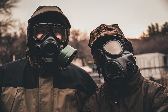 A couple of people dressed in protective clothing and respiration masks. A couple of people dressed in protective clothing and respiration masks.