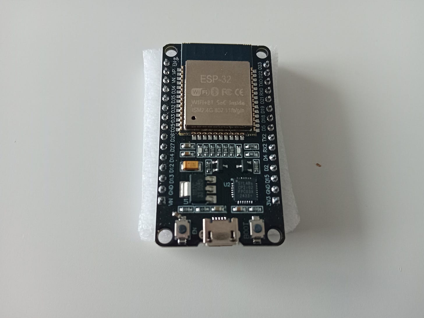 ESP32-DevKitC: elektroniczna płytka rozwojowa, na której widzać moduł ESP-WROOM-32 i inne mniejsze elementy elektroniczne, m. in.: dwa przyciski, złącze umożliwiające podpięcie płytki do komputera, diody LED, rezystory, konwerter UART ↔ USB, tranzystory. Z płytki są wyprowadzone gold piny z opisem. ESP32-DevKitC: elektroniczna płytka rozwojowa, na której widzać moduł ESP-WROOM-32 i inne mniejsze elementy elektroniczne, m. in.: dwa przyciski, złącze umożliwiające podpięcie płytki do komputera, diody LED, rezystory, konwerter UART ↔ USB, tranzystory. Z płytki są wyprowadzone gold piny z opisem.