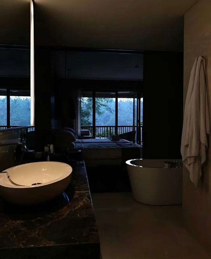 This may contain: a bathroom with a tub, sink and large windows