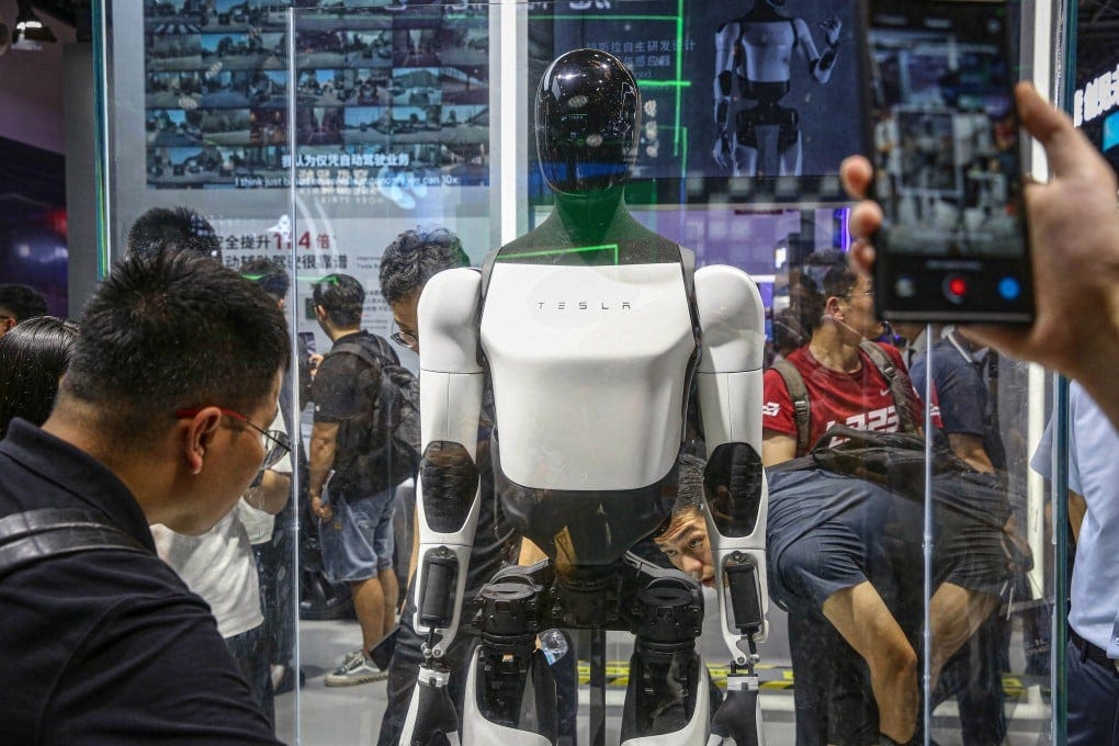 Visitors look at Tesla’s Optimus robot at its exhibition booth during the World Artificial Intelligence Conference in Shanghai in July 2024. Photo: AFP/Getty Images/TNS