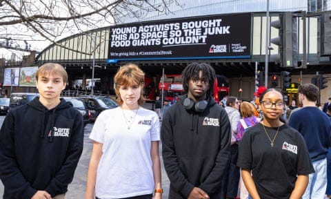 Young activists in front of a Bite Back 2030 billboard aimed at reducing children’s exposure to junk food ads. Young activists in front of a Bite Back 2030 billboard aimed at reducing children’s exposure to junk food ads.