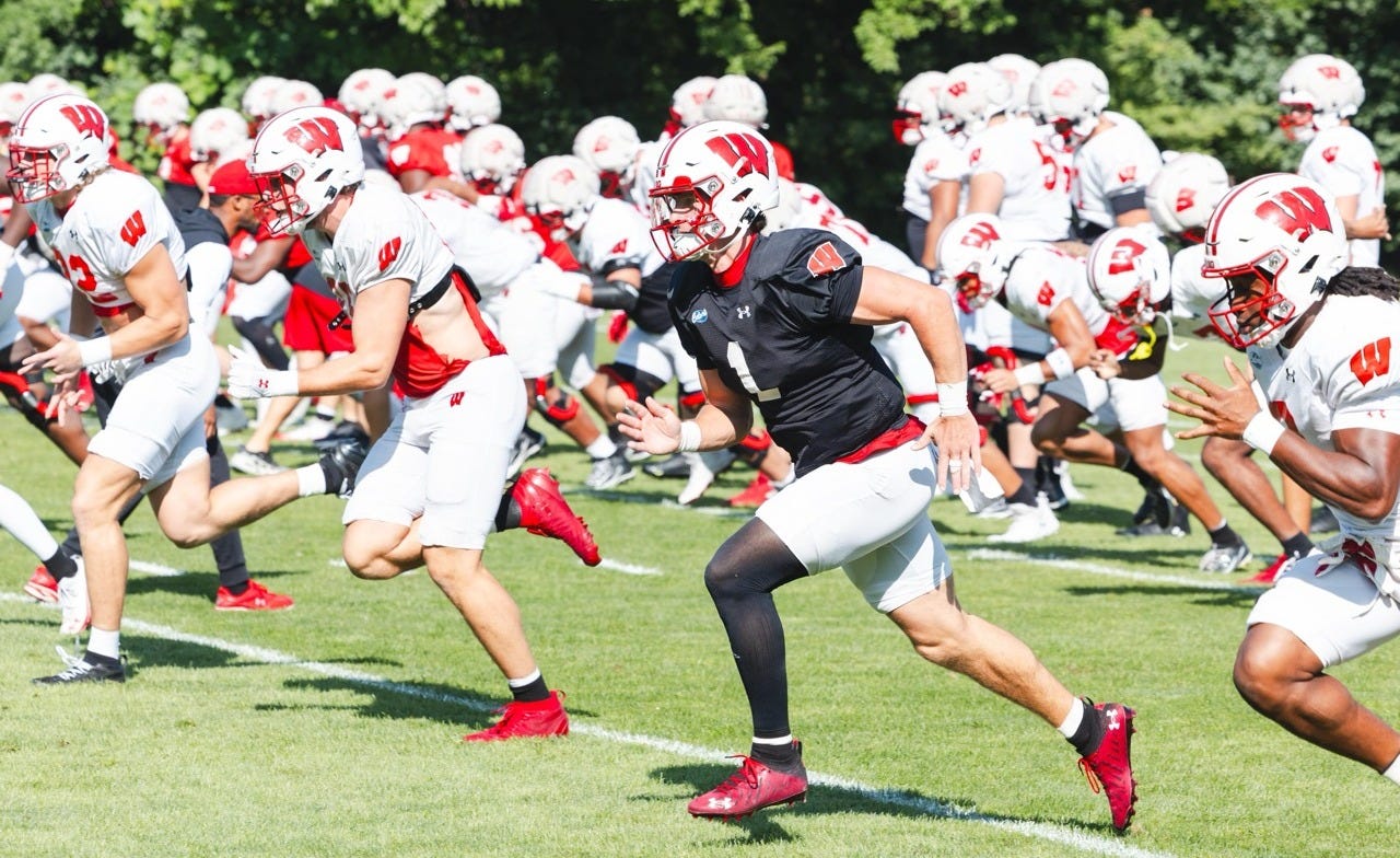 Wisconsin Badgers quarterback Colton Joseph runs on the field during warmups at a fall camp practice.