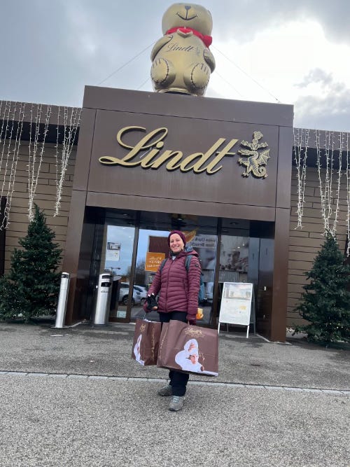 Me infront of the Lindt Chocolate factory outlet holding two full bags of chocolates.