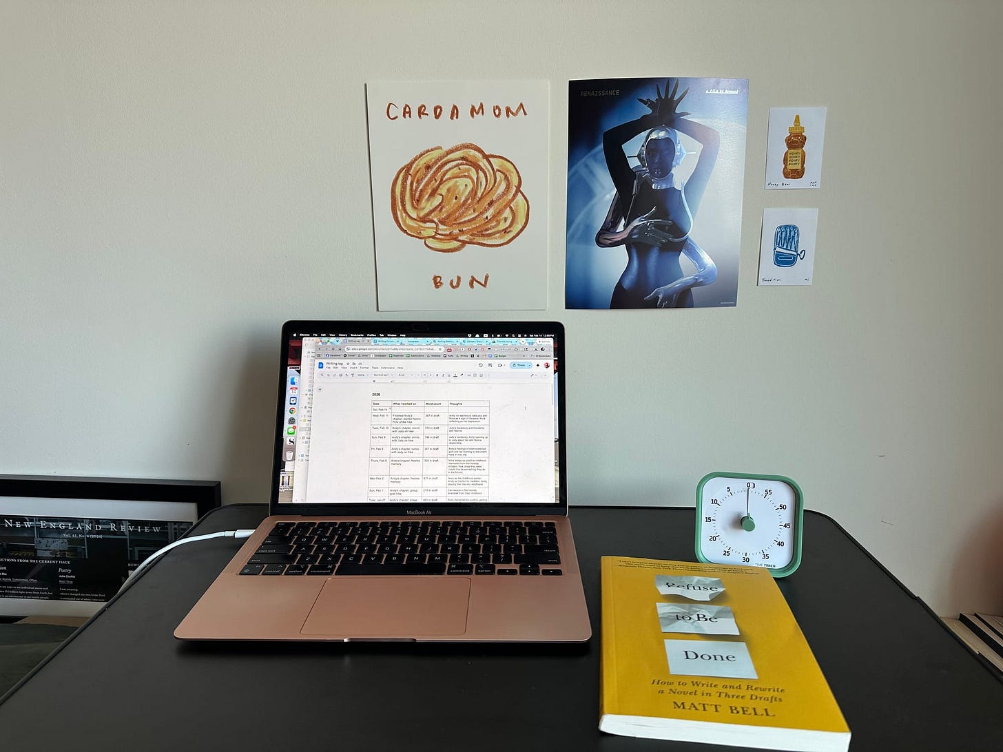 Nicole's desk with her laptop, a copy of Matt Bell's "Refuse to Be Done," and a timer