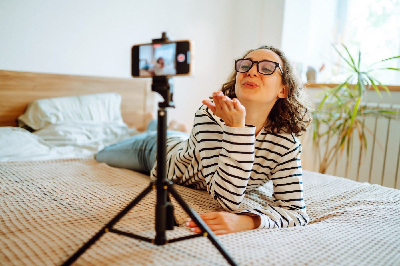 Woman making a video of herself with a cell phone.