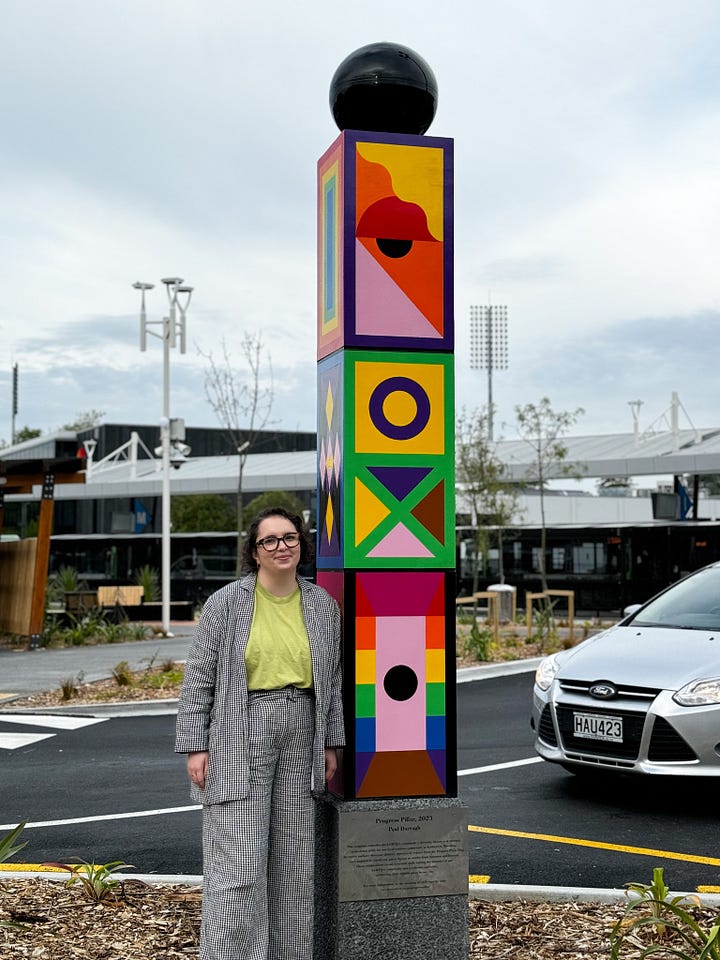 Two photographs from the upgraded transport centre - in front of the new decals on the windows, and one of Louise next to the sculpture they crowd-funded.