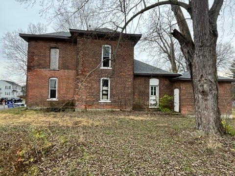 A brick house with a tree in the back
AI-generated content may be incorrect.