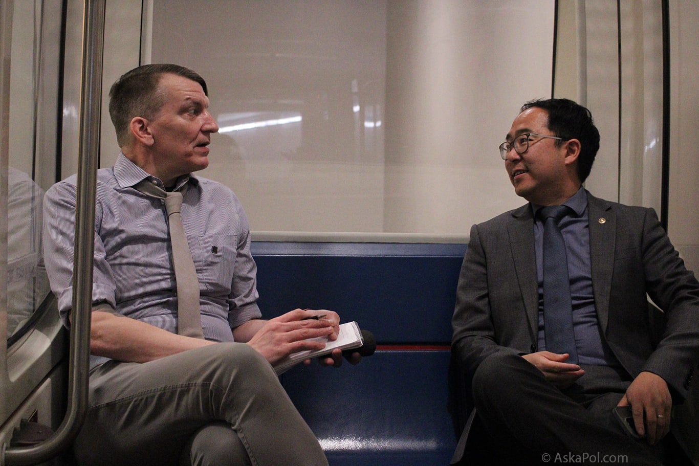 White male and Asian male is suit talk on tram side Photo: Logan Johnson © www.AskaPol.com White male and Asian male is suit talk on tram side Photo: Logan Johnson © www.AskaPol.com