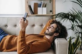 using smart phone relaxing on sofa ...