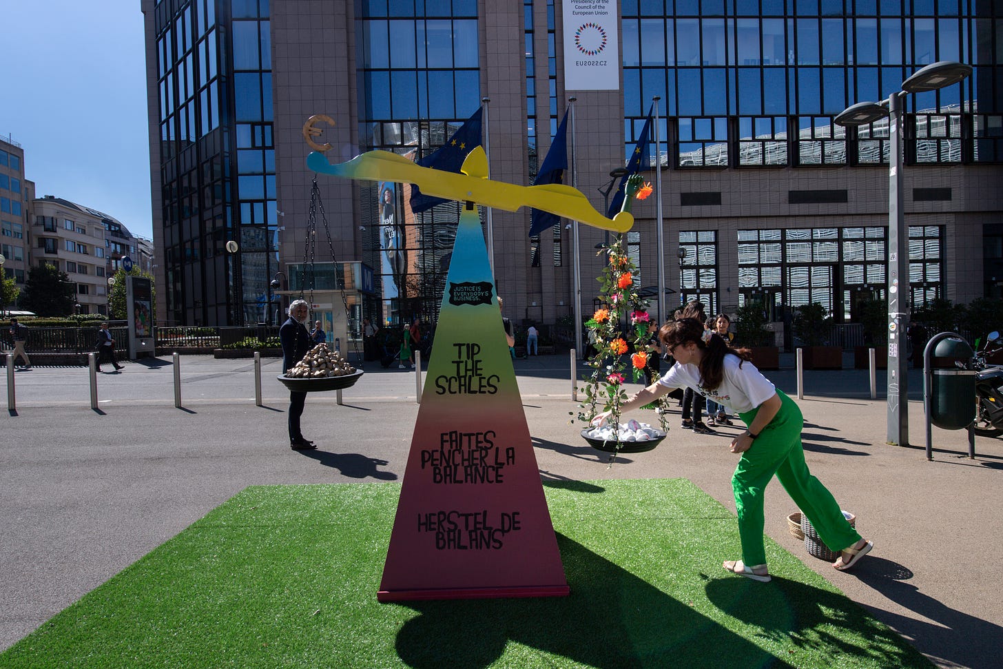 Campaigners at the giant artificial scales add pebbles to the weights to tip the scales