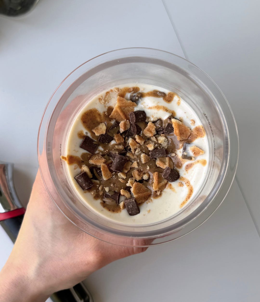 Close-up of a creamy chocolate peanut butter cup Ninja Creami in a bowl with crunchy waffle cookie pieces and dark chocolate chunks on top