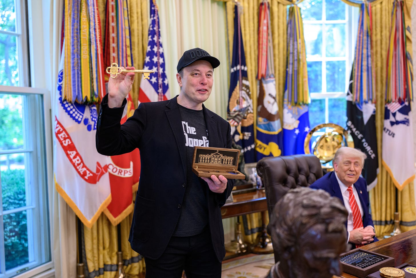 Musk holds up a golden key Musk holds up a golden key