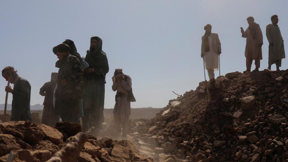 Afghan men stand on the debris of damaged houses after the recent earthquake, in the district of Zinda Jan, in Herat, Afghanistan October 10, 2023.
