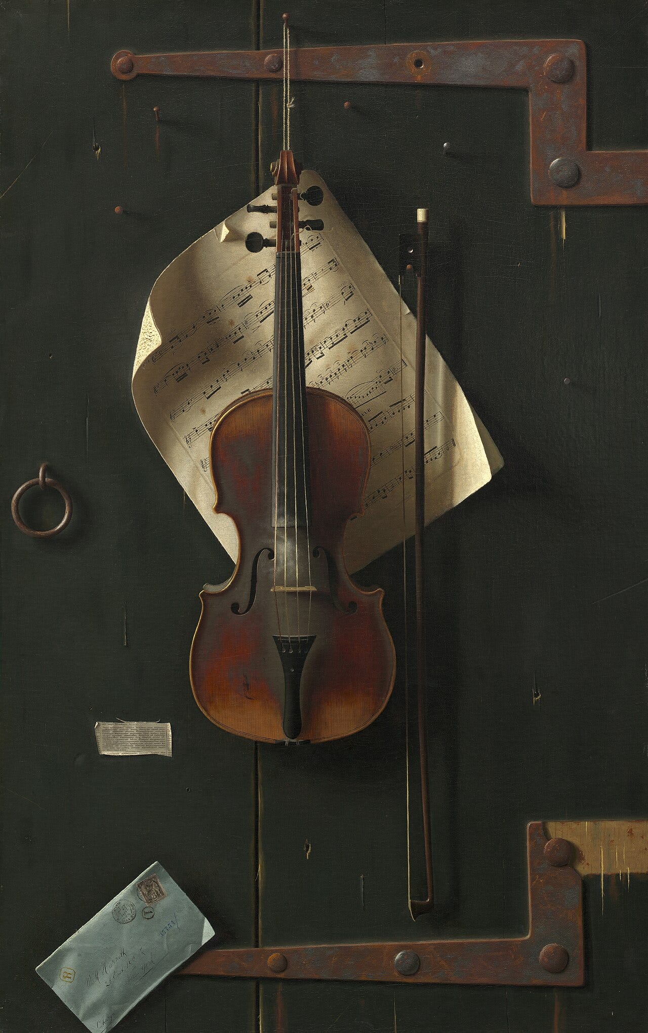 A life size violin hung on a battered green door A life size violin hung on a battered green door