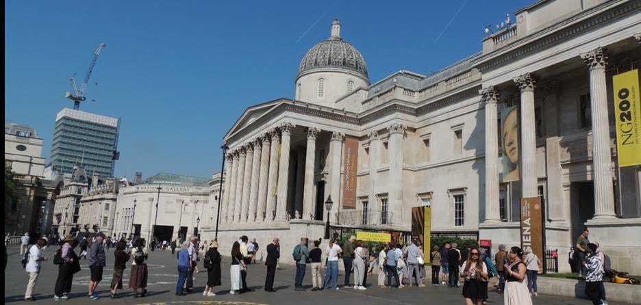 A group of people standing in front of a large building

AI-generated content may be incorrect.