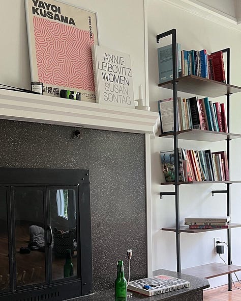 an office; drinks outside on a tray table; a fireplace and a bookshelf.