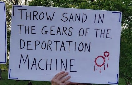 A handheld sign reads "Throw Sand In The Gears of the Deportation Machine"