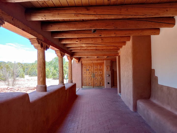 Gift shop with books and souvenirs, museum displays including basketry and diorama of the Pecos Pueblo, view from cloister of semi-desert with trees